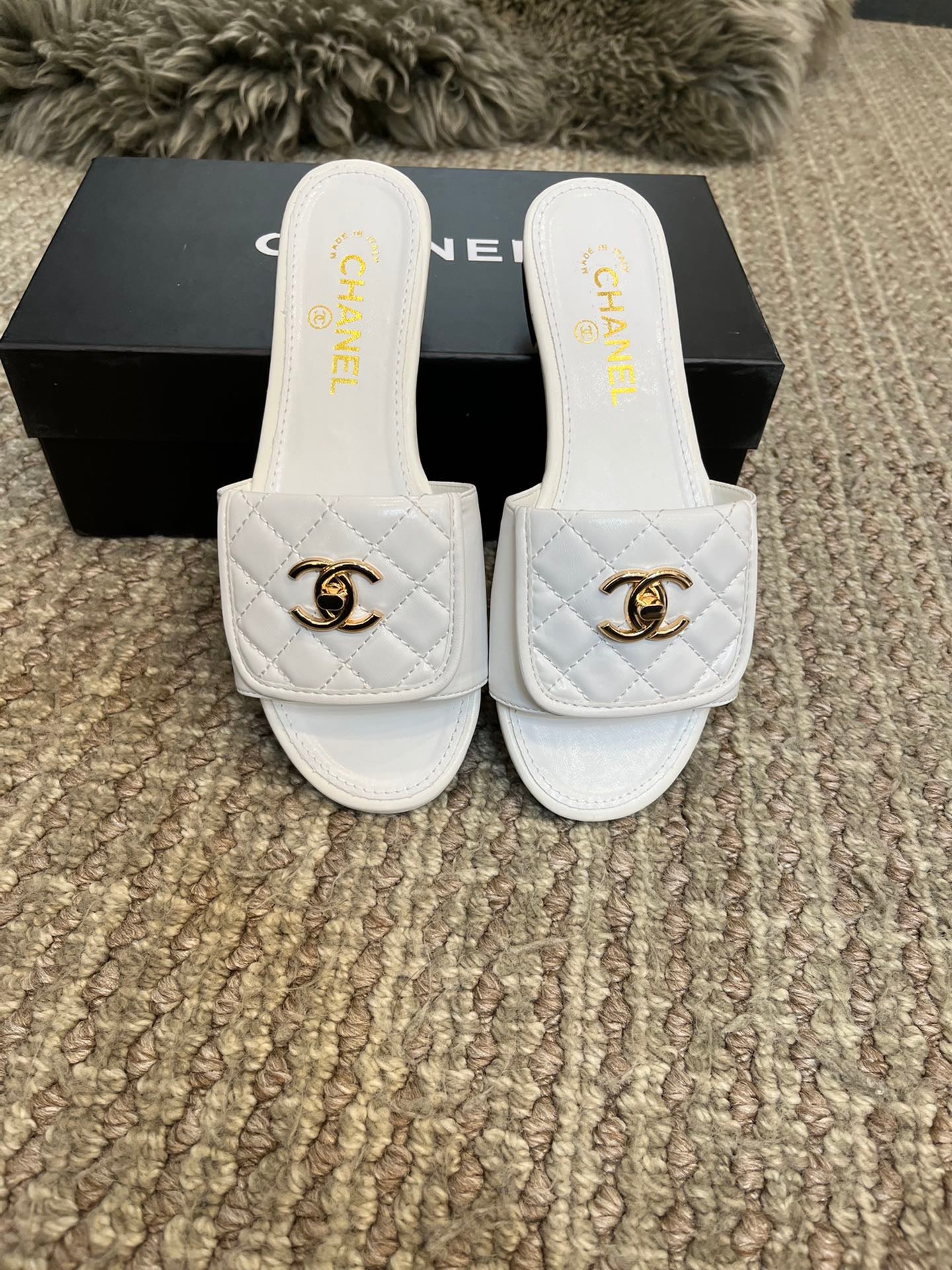 Chanclas planas de lujo con acolchado de rombos y adornos metálicos